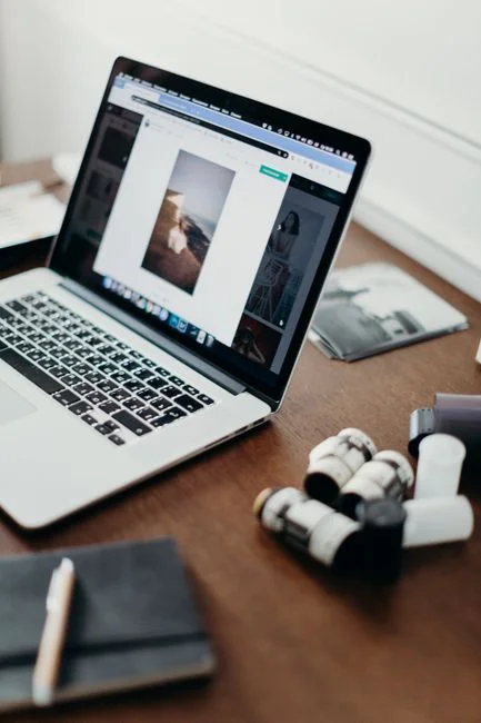 A well-lit desk arrangement with a design book, laptop, and creative tools, perfect for sparking inspiration.